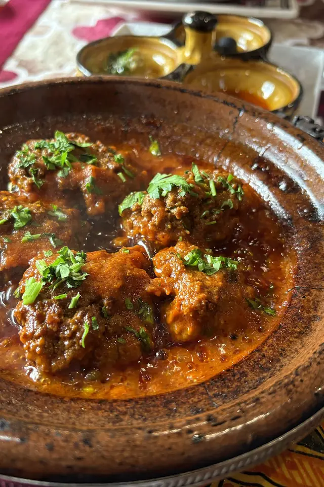 Parujący tajine z duszoną wołowiną i natką w glinianym naczyniu